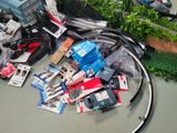 a pile of electronics on the floor next to a plant