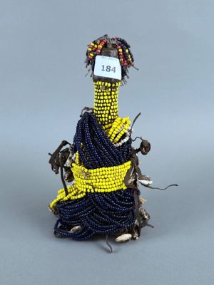 une photo d'une figurine représentant une femme en robe bleue avec une ceinture jaune