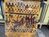 many tools hanging on the wall of a workbench