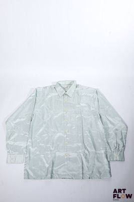 une image représentant une chemise blanche posée sur une surface blanche