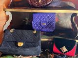 several purses are stacked on top of each other on a shelf