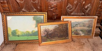 trois tableaux encadrés posés sur un banc en bois devant un mur
