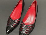 a pair of black and red shoes on a gray surface