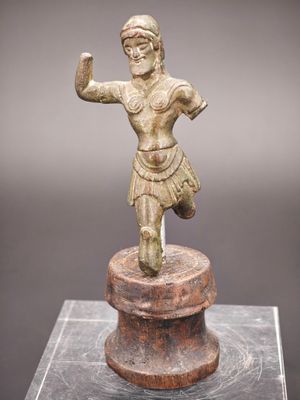 une figurine en bronze représentant un homme, posée sur un socle