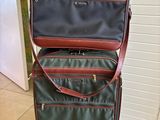 two pieces of luggage sitting on top of each other on a tiled floor
