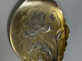 a silver spoon with a flower on it on a table