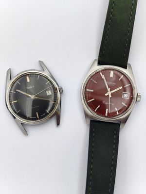 deux montres assises l'une à côté de l'autre sur une surface blanche