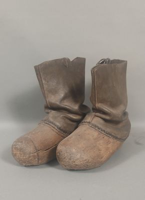 pair of brown leather boots sitting on top of a white surface