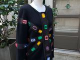 black sweater with multi colored buttons on a mannequin