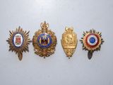 quatre insignes de formes et de couleurs différentes sur un fond blanc