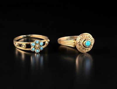 deux bagues en or ornées de turquoises sur un fond noir