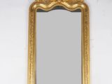 un miroir au cadre doré ouvragé accroché au mur au-dessus d'un lavabo