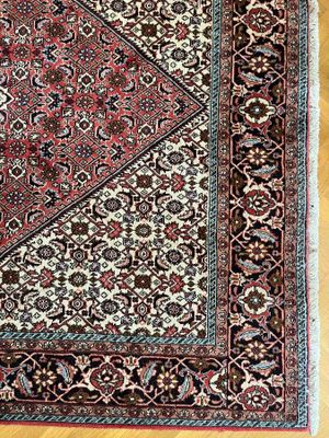 un gros plan d'un tapis oriental posé sur un parquet