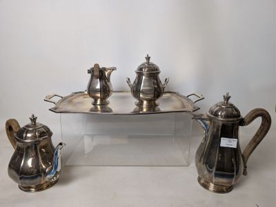 three silver teapots and a tray on a table