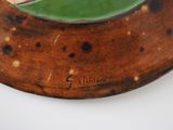 a plate with a green leaf on it on a table
