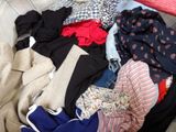 a pile of clothes sitting on the floor next to a bed