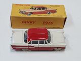 a red and white toy car in front of a box