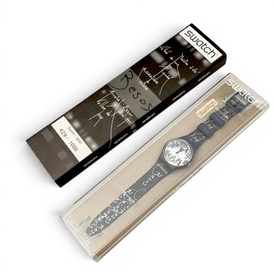 a black and white watch in a box next to a black and white watch