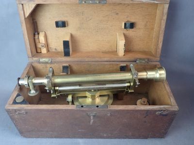 une boîte en bois contenant un cylindre en laiton