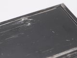 a small black box with a black top on a white surface