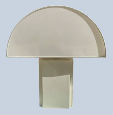 a white table lamp with a white shade on top of it