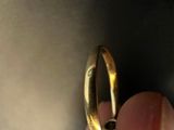 a person holding a gold ring in their left hand
