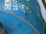 un réservoir bleu auquel est raccordé un tuyau vert