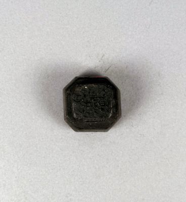un gros plan d'un petit objet noir sur une surface blanche