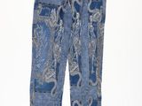 un pantalon en jean à motif cachemire et ceinture, sur fond blanc
