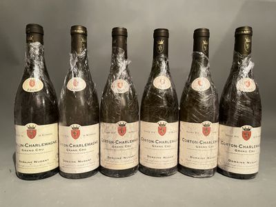 six bottles of wine are lined up in a row on a table
