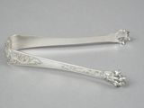 pair of silverware spoons with floral designs on them on a white surface