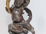 an antique bronze statue of a boy holding a bird on a pedestal