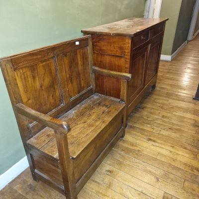 un banc en bois dans un coin de la pièce, à côté d'une commode