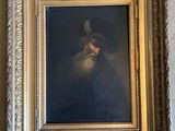 tableau représentant un homme coiffé d'un chapeau et portant une barbe, dans un cadre doré accroché au mur