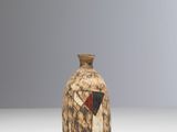 un petit vase orné d'un motif rouge et noir