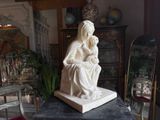 a statue of a woman sitting on top of a table