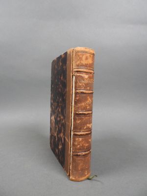 an old book sitting on top of a table next to a gray background