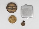 some coins and a medal are sitting on a white surface