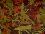 a close up of a red and gold box with a bird on top of it