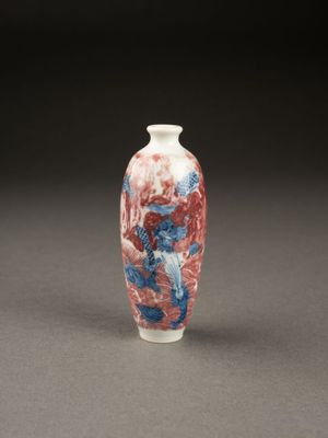 un vase rouge et bleu posé sur une table