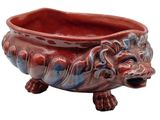 a red and blue bowl with a lion head on it