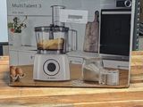 une boîte posée sur une table en bois dans un magasin, avec un appareil électroménager en arrière-plan