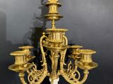 an antique brass candelabra with five candles on a marble base
