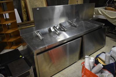 a stainless steel sink in the middle of a room