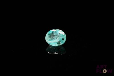 a close up of a green glass bea on a black surface