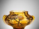 une image représentant un vase en verre jaune orné d'un motif d'oiseau