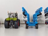 four toy tractors that are lined up in a row