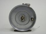 a metal reel that is sitting on a white surface