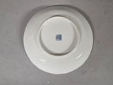 a white plate with a blue stamp on it on a table