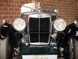 a vintage car that is parked in front of a brick wall